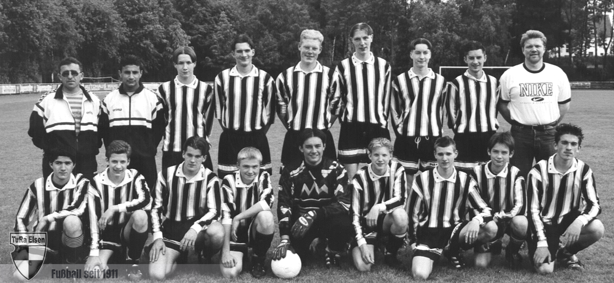 Schwarz-weiß Gruppenfoto der B-Junioren Kreismeister 1999 von TuRa Elsen, 14 Spieler in gestreiften Trikots und zwei Trainer auf Fußballfeld