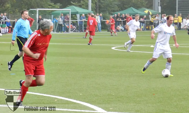 Ü50 Westfalen Meisterschaft im Elsener Dreizehnlinden Stadion Fußballspiel mit Spielern in roten und weißen Trikots auf einem Kunstrasenplatz, Schiedsrichter in blau