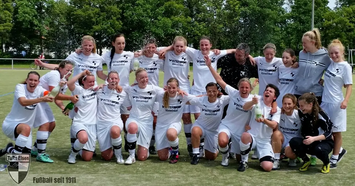 TuRa-Frauen feiern Meisterschaft und Aufstieg auf dem Unisportplatz Frauenfußballteam in weißen Trikots feiert mit Sekt auf einem Fußballfeld, einige knien, andere stehen