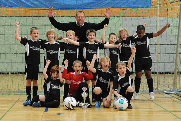 Den Silvestercup-Sieg bei den F-Junioren bejubeln Trainer Frank Nübel sowie die TuRa-Kicker (hinten v. l.) Linus Arenhövel, Nico Vorderwisch, Tjark Jahnke, Florian Schindler, Marcel Kleppner, Fynn Nübel und Ebuka Okoroafor sowie (vorne v. l.) Gianluca di Marca, Torwart Benedikt Kräußel, Anno Droste und Nils Ole Kirchhoff. | FOTO: MARC KÖPPELMANN