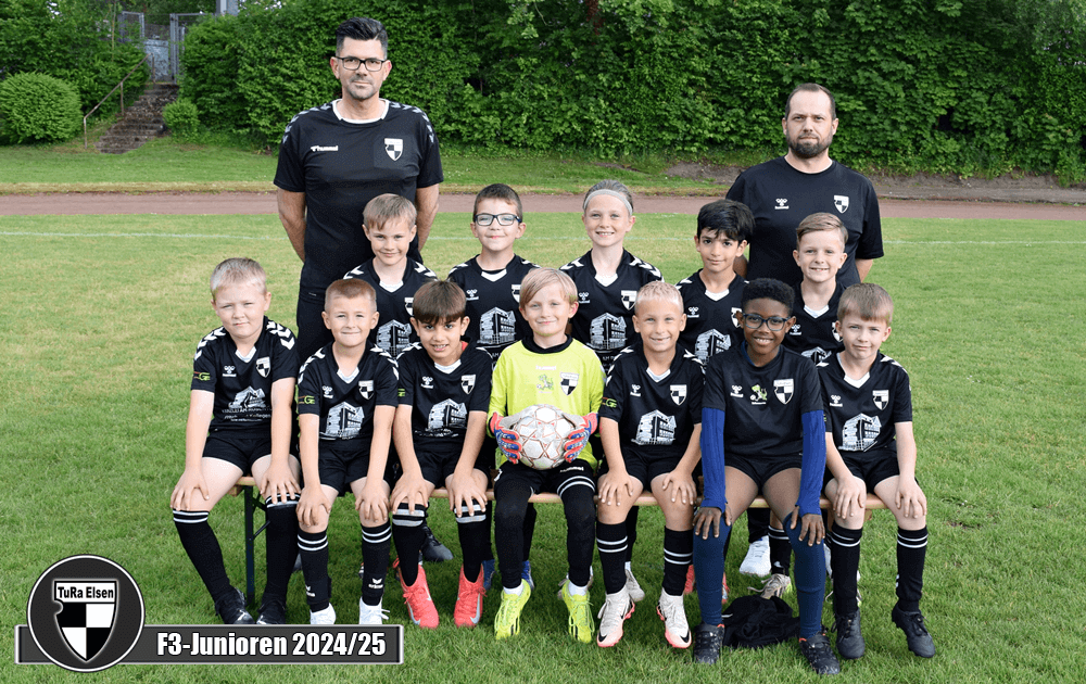  Fußballteam der F3-Junioren 2024/25 der TuRa Elsen mit 12 Kindern in schwarzen Trikots und zwei Trainern auf dem Sportplatz