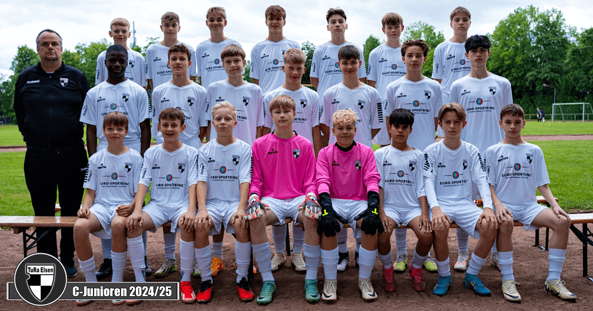 Mannschaft der C-Junioren TuRa Elsen mit Trainer, 20 Spieler in weißen Trikots und zwei Torhütern in pinken Trikots auf Sportplatz