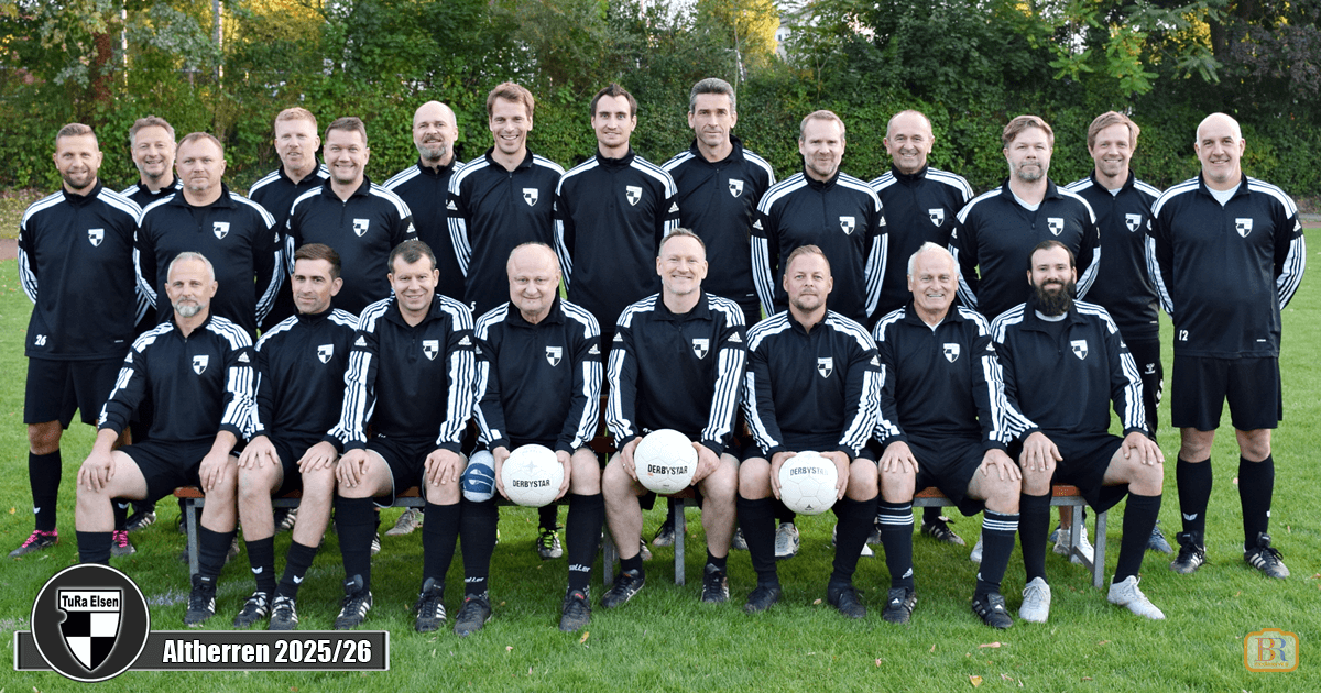 Mannschaftsfoto der TuRa Elsen Altherren mit 22 Spielern in schwarzen Trainingsanzügen, sitzend und stehend auf einem Fußballfeld.