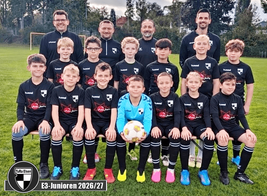 Mannschaftsfoto der E3-Junioren der TuRa Elsen mit Spielern in schwarzen Trikots und vier Trainern im Hintergrund auf einem Fußballfeld